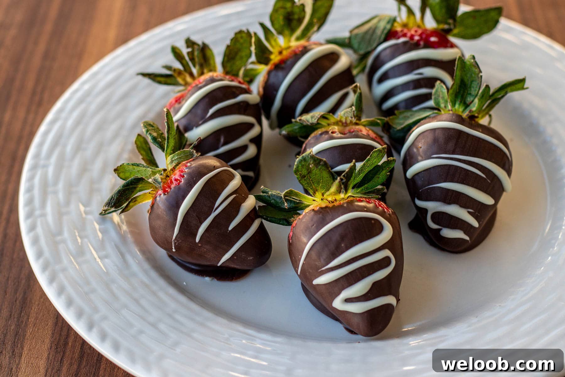 landscape photo of chocolate covered strawberries on a plate