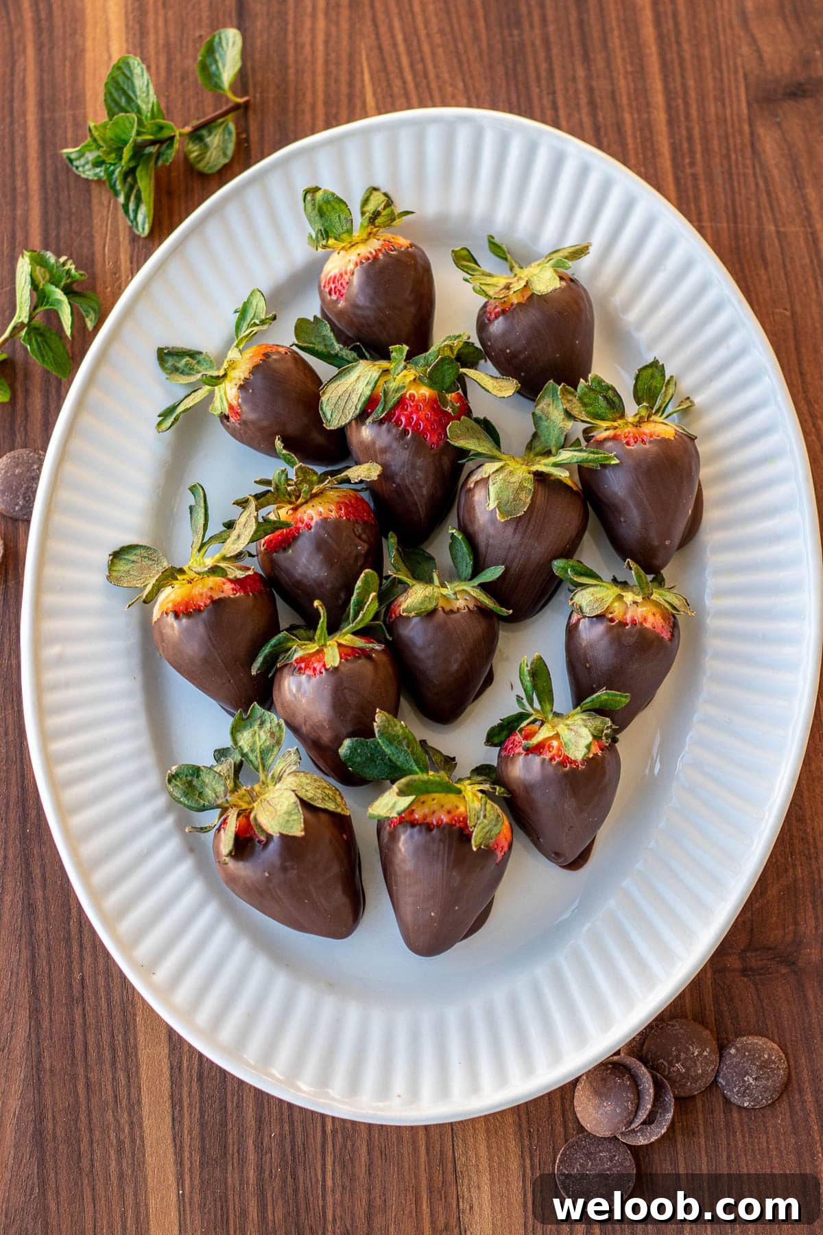 Strawberries covered in chocolate on a serving platter