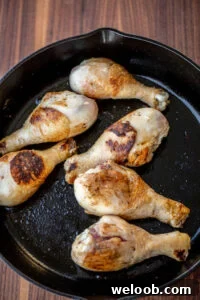 Browned chicken drumsticks in cast iron skillet