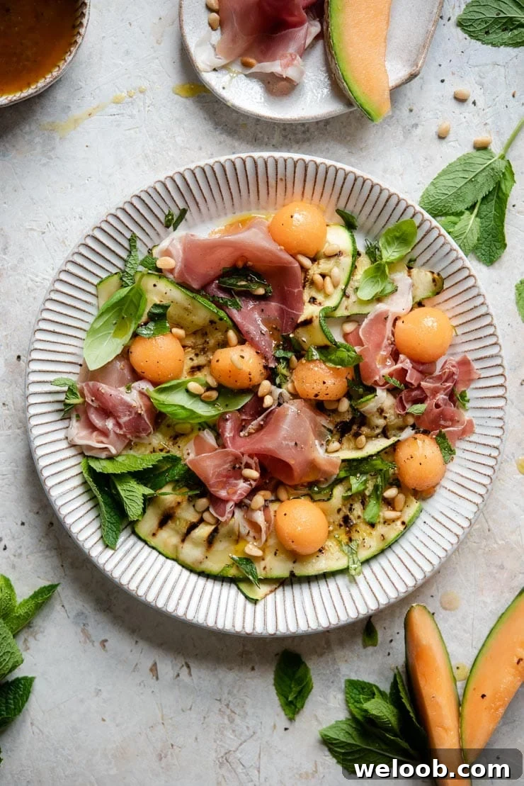 An overhead shot of a zucchini salad on a rustic stone plate