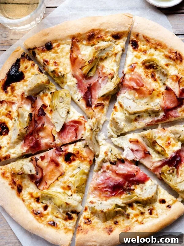 An overhead shot of an artichoke pizza cut into slices