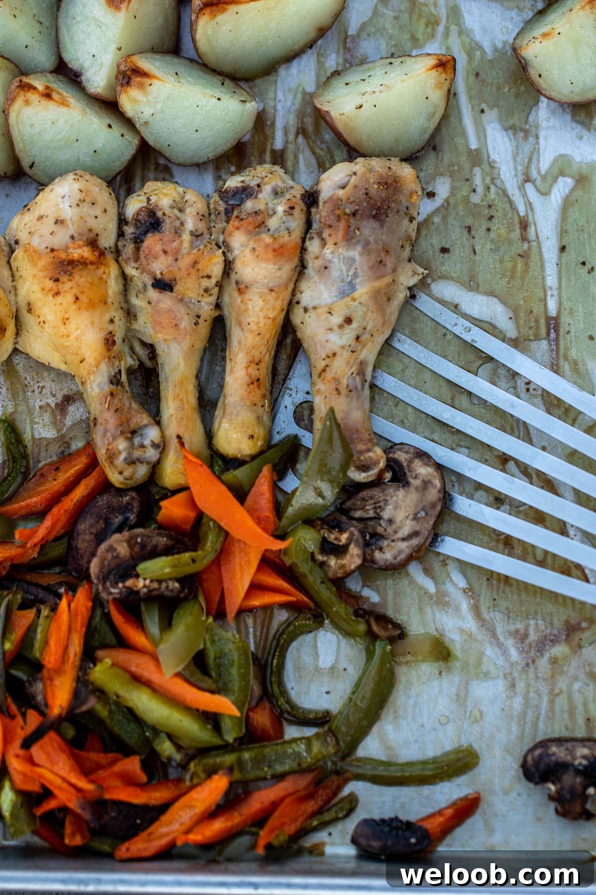 One pan chicken and potatoes and veggies being dished with a fish spatula