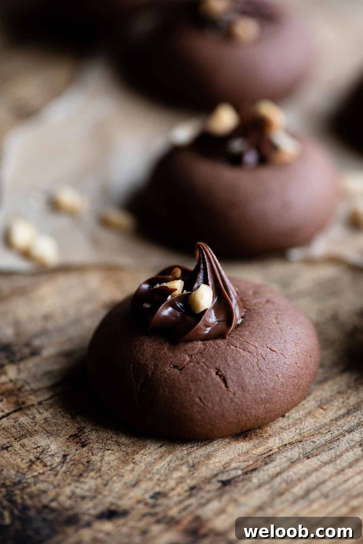 A close up side shot of a Nutella cookie topped with Nutella and hazelnuts.