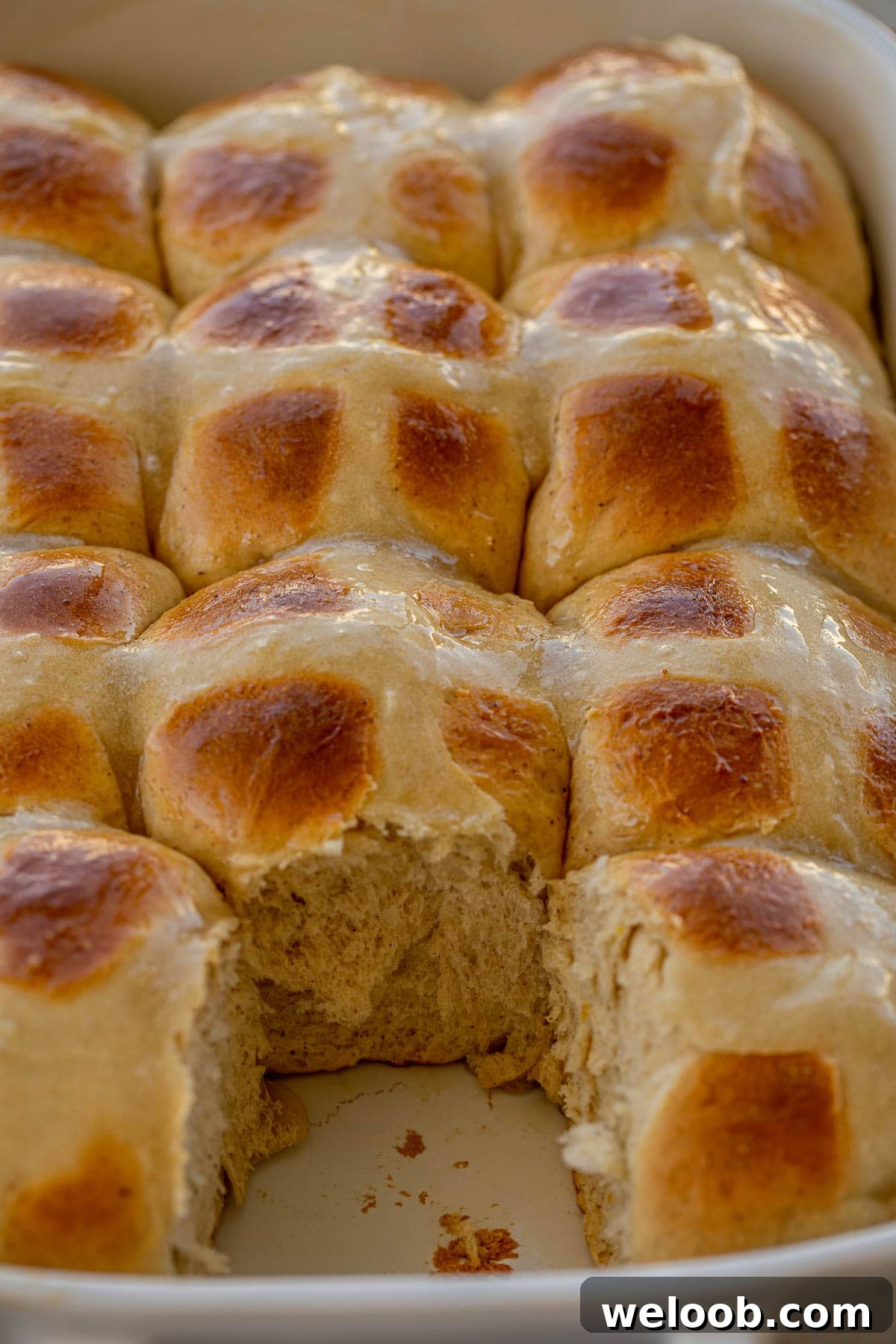 Hot Cross Buns in a baking dish with one removed