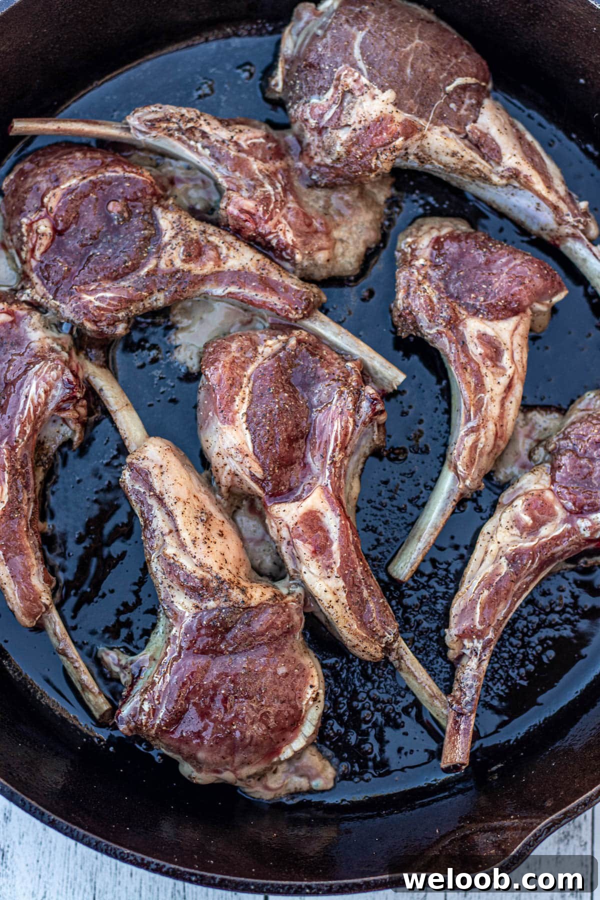 Lamb chops added to hot cast iron skillet.