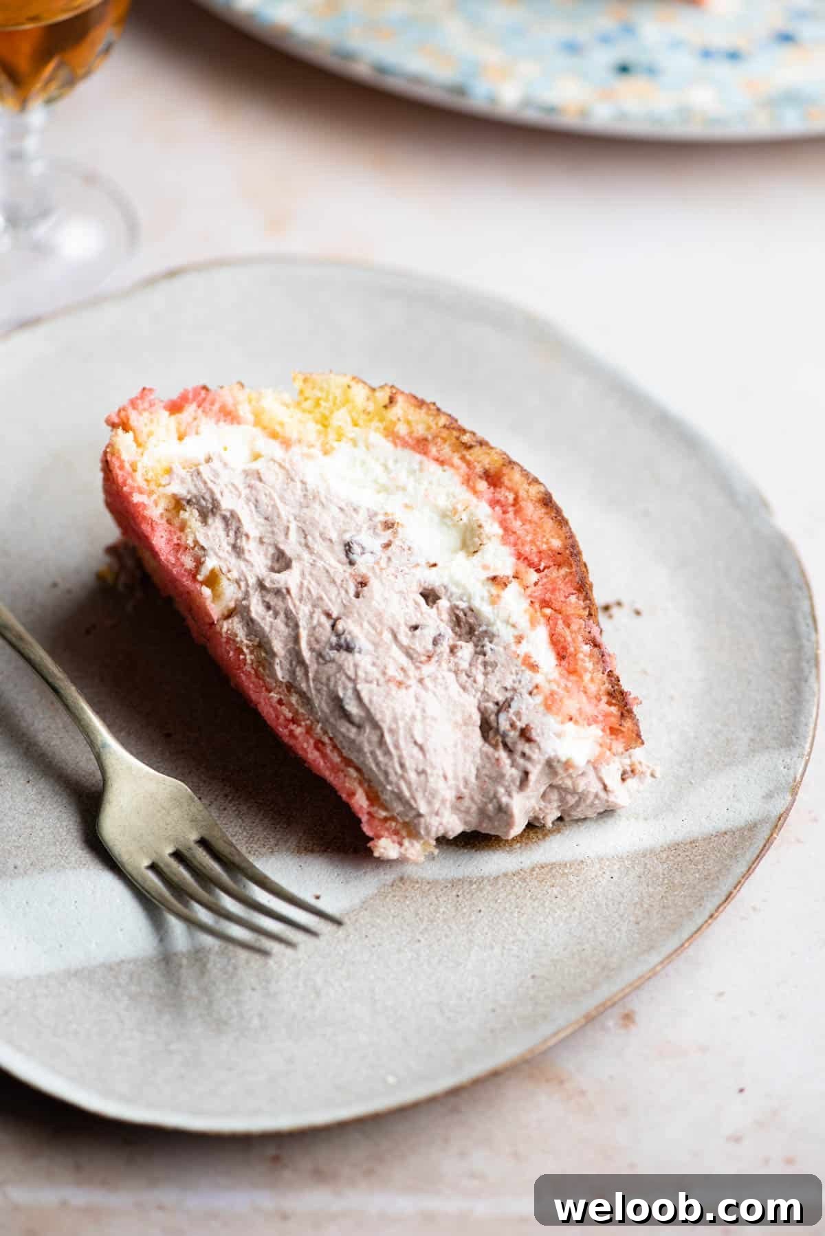 A slice of Italian Zuccotto cake on a plate with a fork at the side.