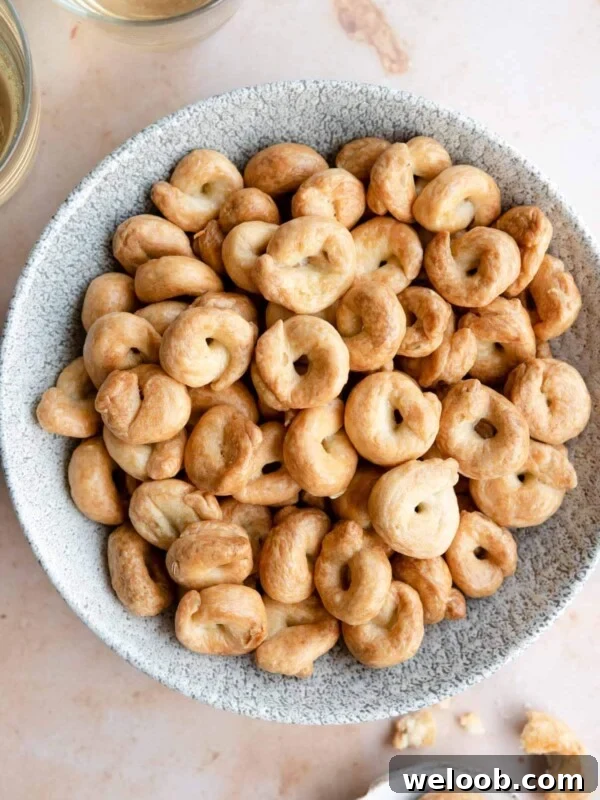 An overhead shot of Taralli in a bowl with glasses of wine at the side