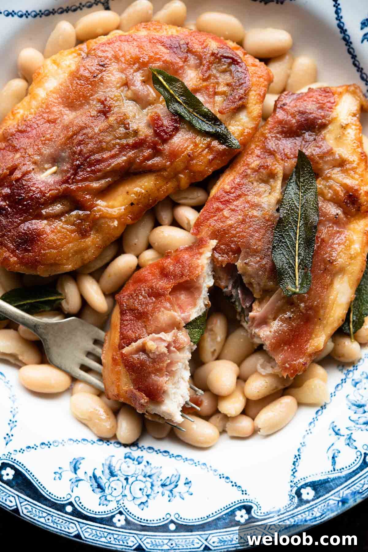 A close up of chicken saltimbocca on a plate with beans and sage.