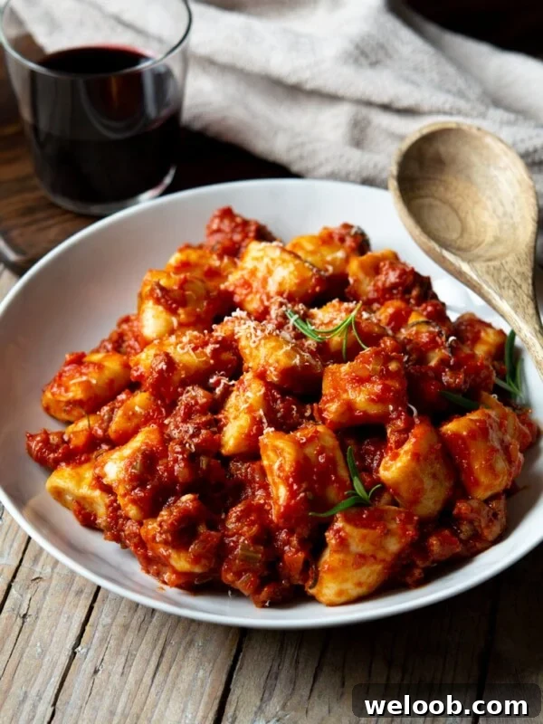 Sausage ragu with ricotta gnocchi in a white bowl