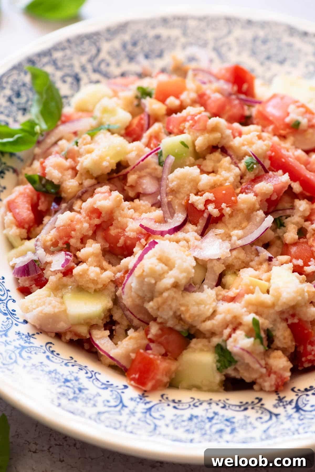 A close up of authentic Panzanella salad in a blue bowl.