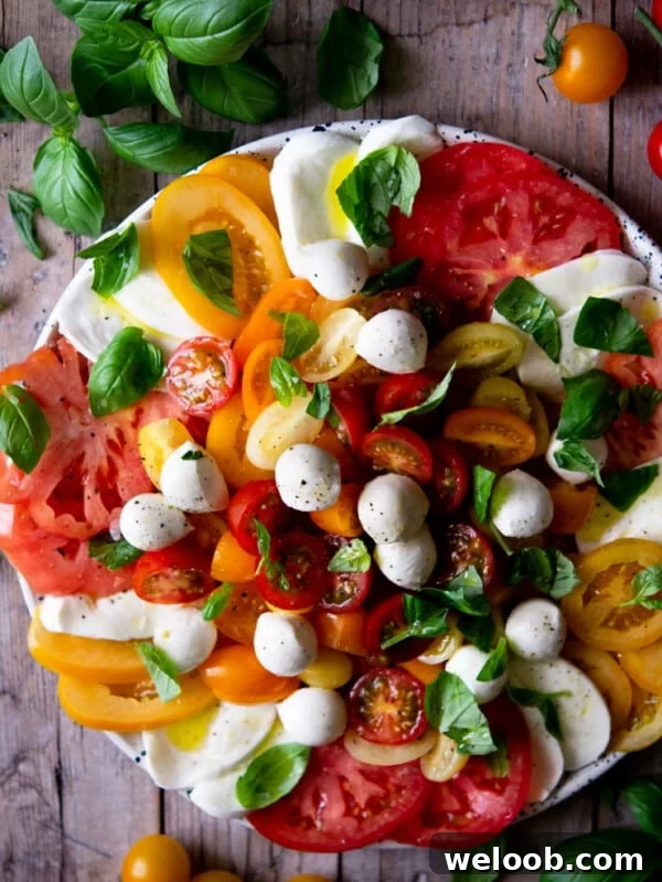 An overhead shot of a caprese salad with vibrant coloured tomatoes