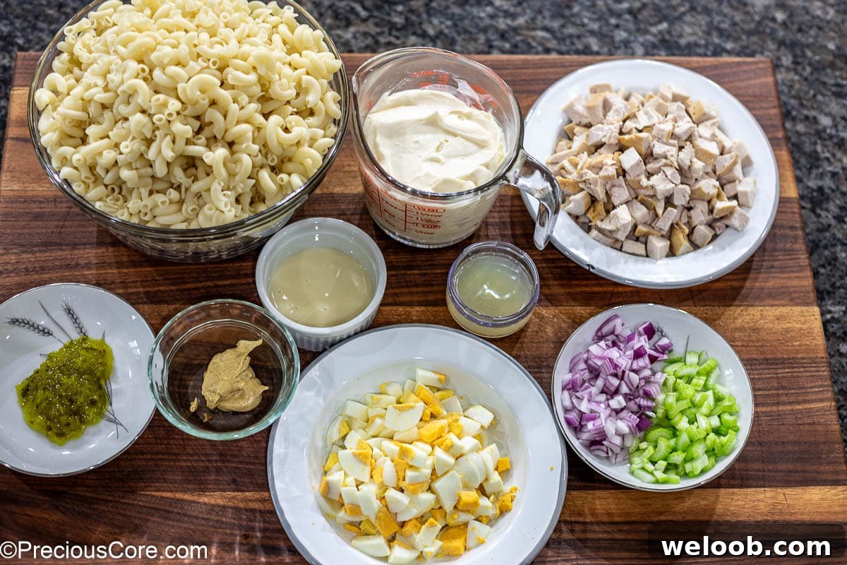 Ingredients for macaroni salad laid out on a chopping board.