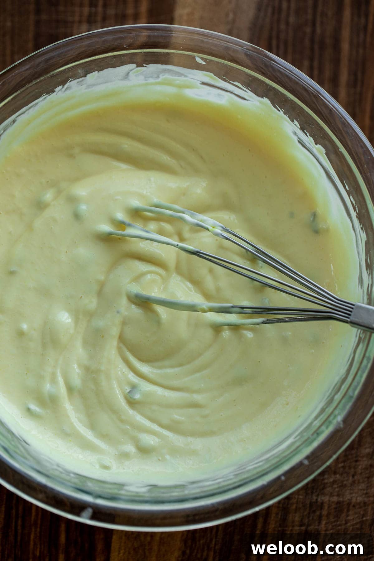 Creamy dressing with a whisk in a bowl