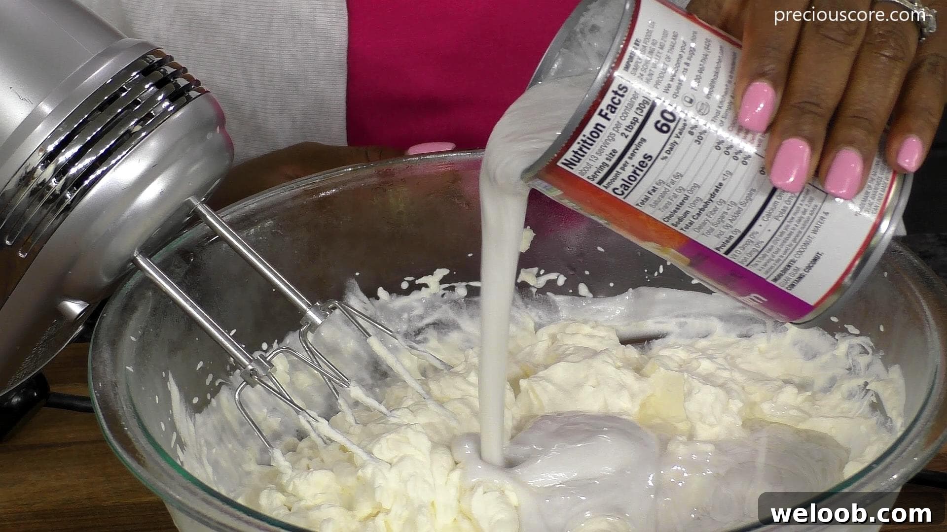 Coconut cream pouring from can into bowl.