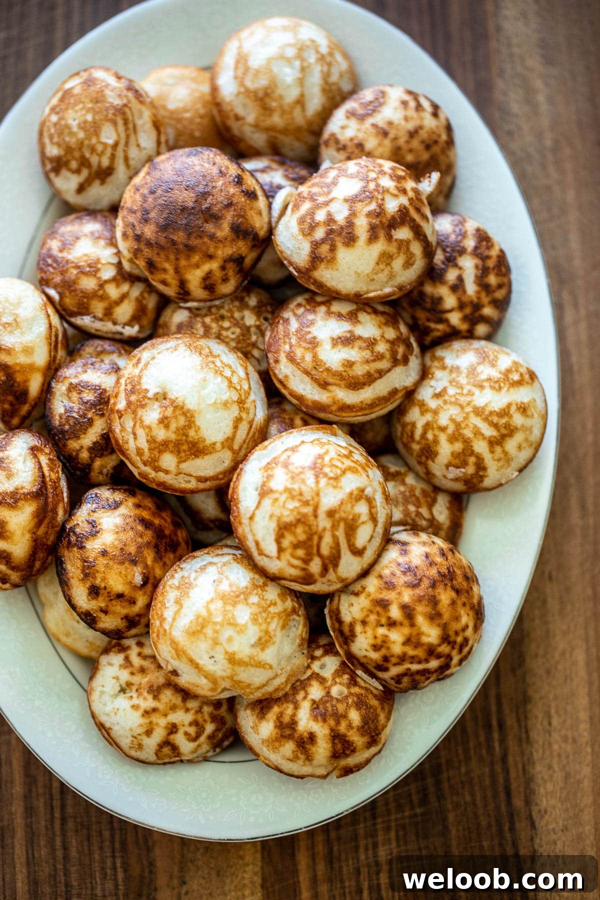 several dozen cooked vitumbua on a white tray.