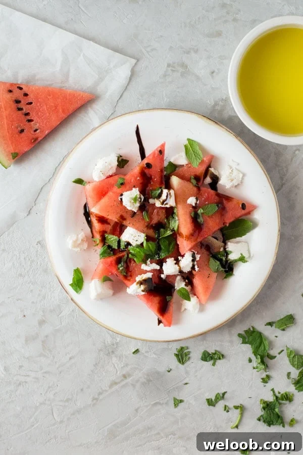 A delicious light watermelon basil salad with mint, goats cheese and balsamic glaze. Refreshing and healthy salad recipe insidetherustickitchen