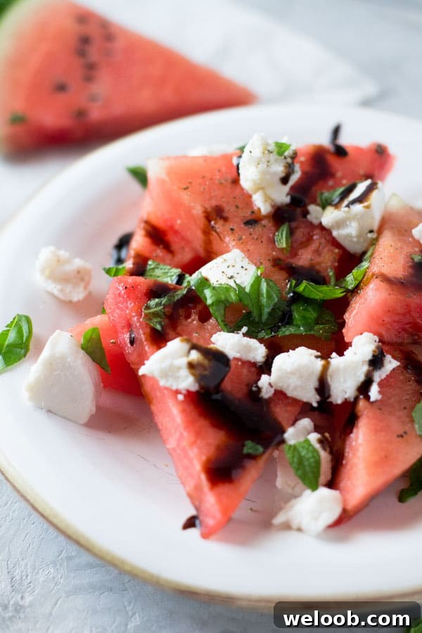 A delicious light watermelon basil salad with mint, goats cheese and balsamic glaze. Refreshing and healthy salad recipe insidetherustickitchen