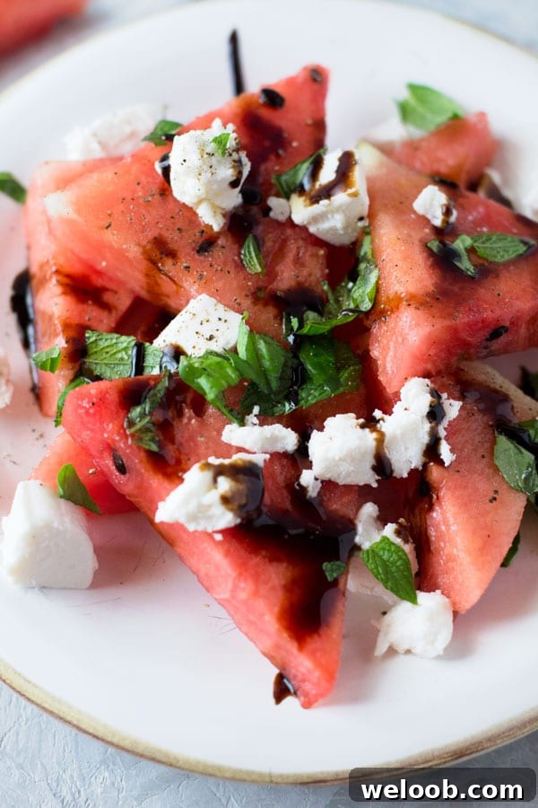 A delicious light watermelon basil salad with mint, goats cheese and balsamic glaze. Refreshing and healthy salad recipe insidetherustickitchen