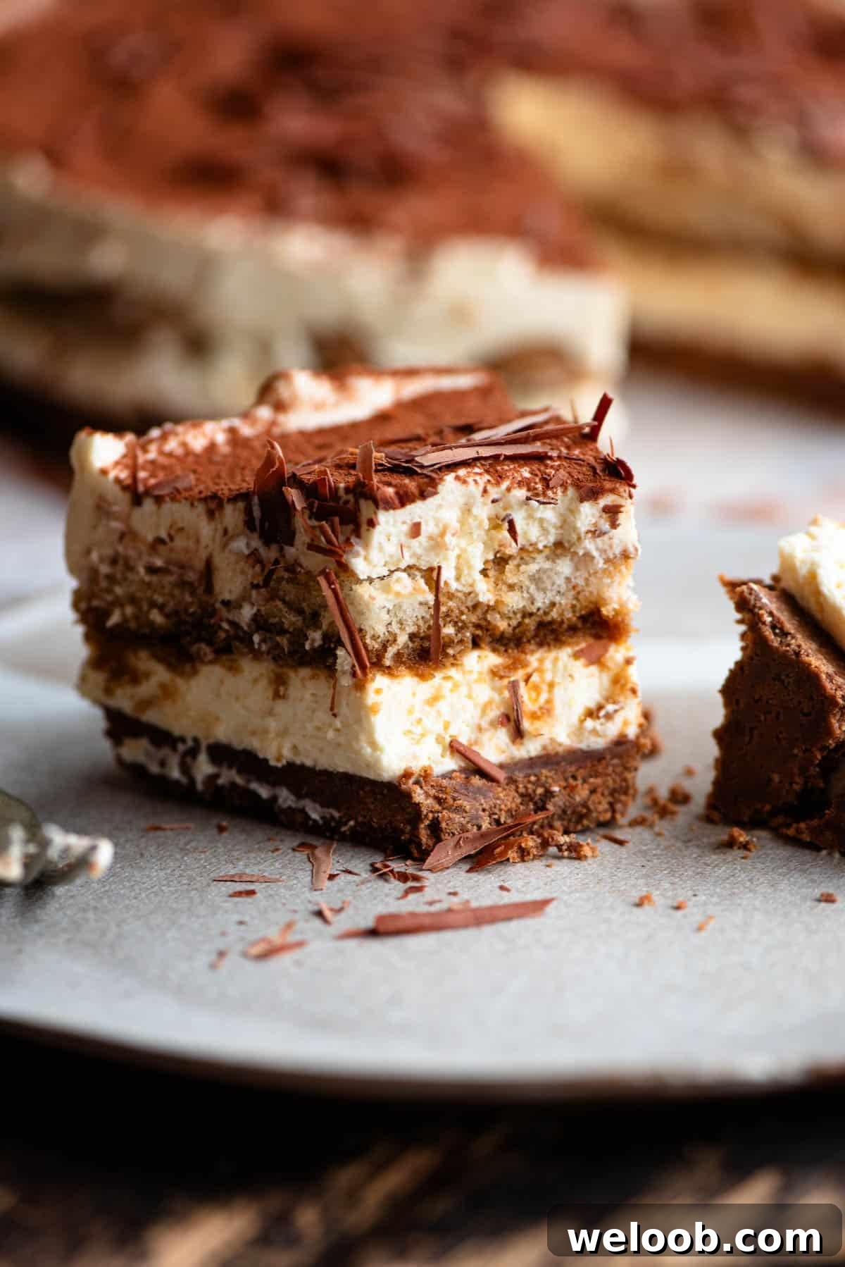 A close up of a slice of tiramisu cheesecake with a bite out.