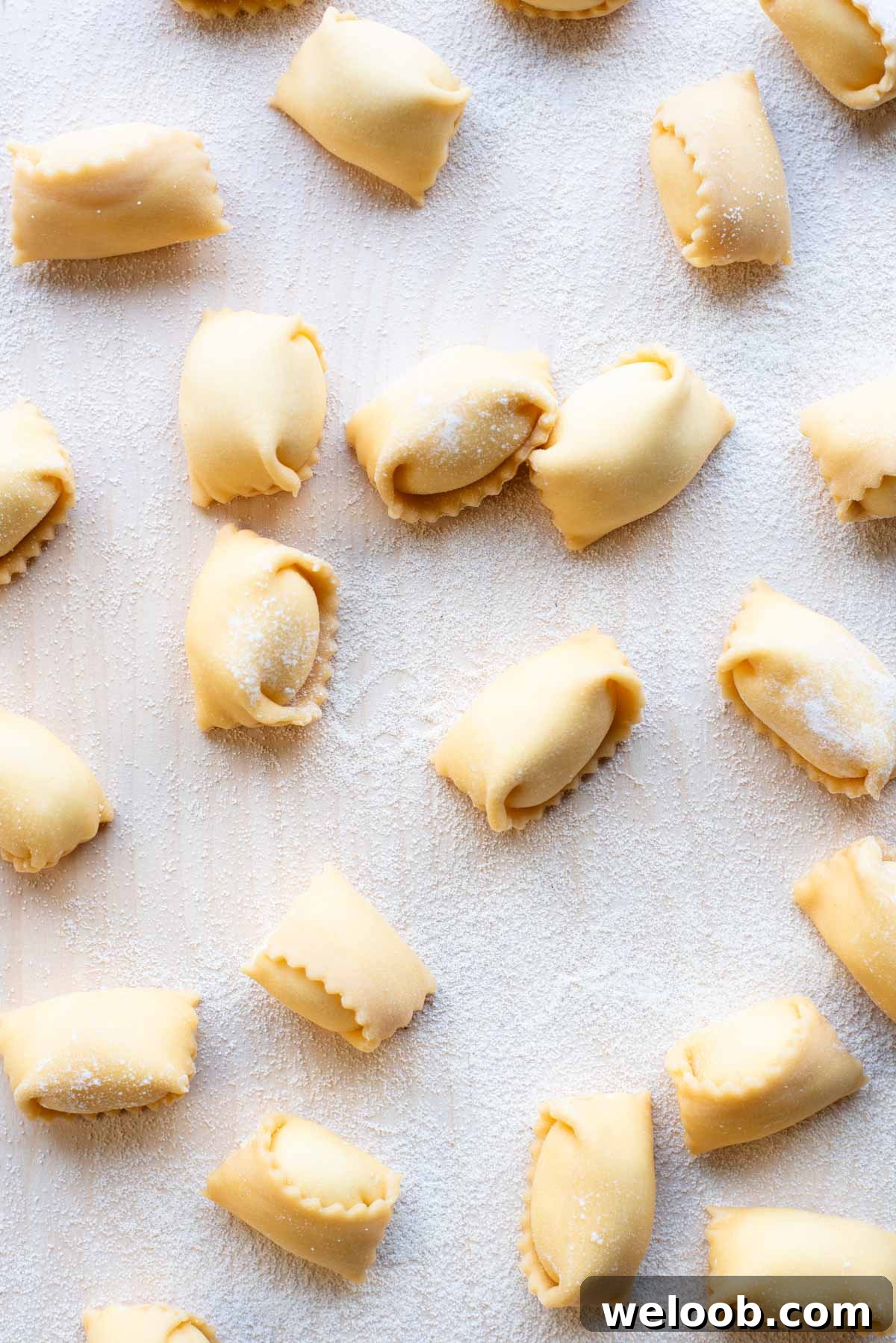 An overhead shot of Agnolotti pasta on a wooden board.