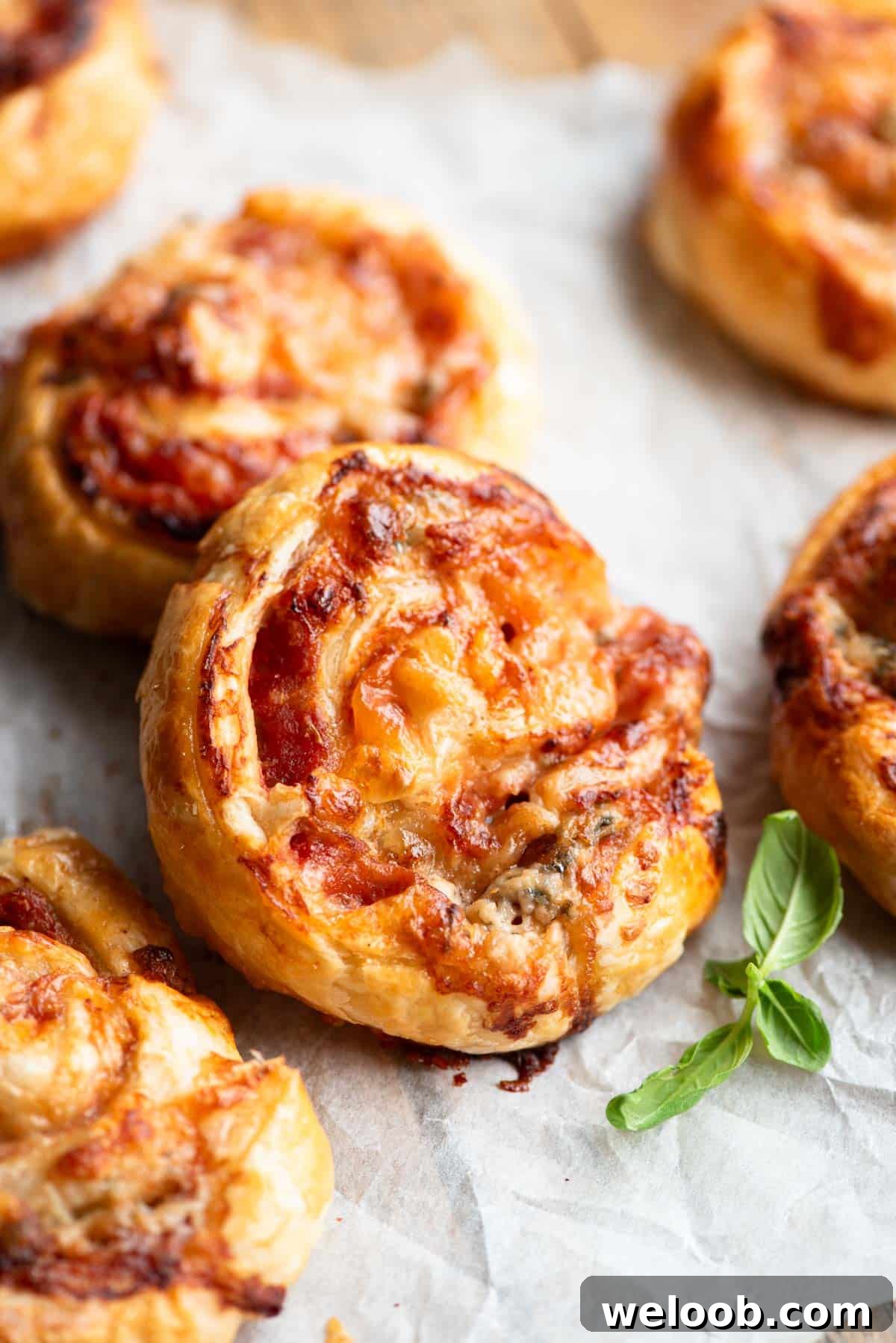 A close up of pizza pinwheels on a wooden board.