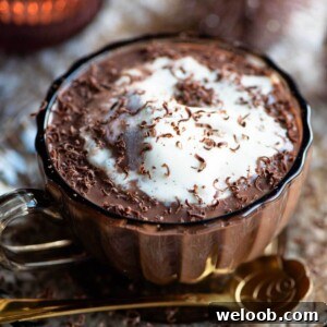 A close up of a hot chocolate affogato topped with vanilla ice cream in a glass mug.