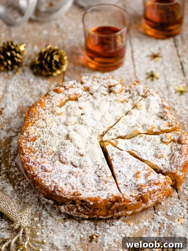 Panforte on a wooden table cut into slices with christmas decorations around
