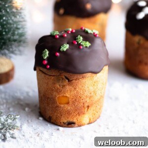 A close up of a mini Panettone topped with melted chocolate and Christmas sprinkles.