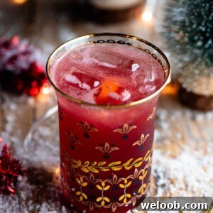 A close up of a Christmas Cocktail made of Cranberry juice and Prosecco in a gold glass.