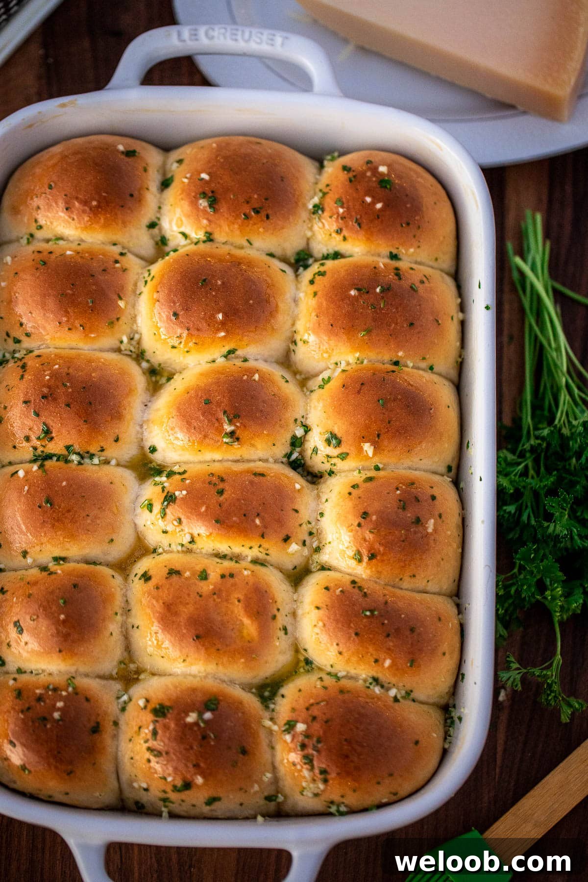 A full baking dish of dinner rolls brushed with garlic butter