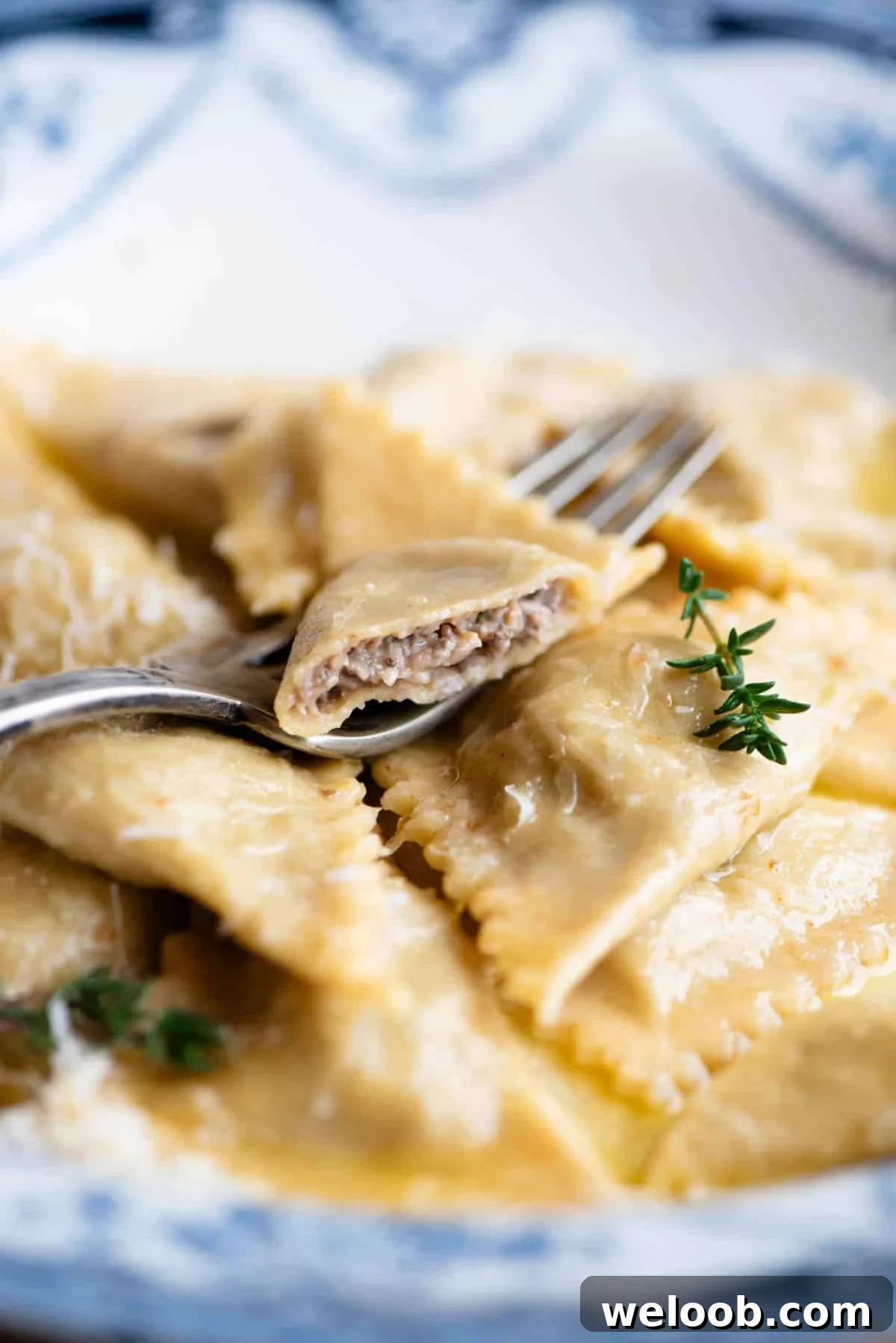 A close up side shot of mushroom and taleggio Triangoli pasta with one cut open to see the filling inside.