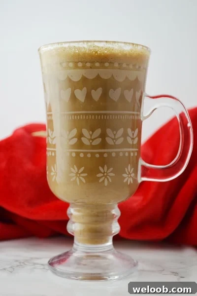 Banana milk coffee in a glass mug on a white surface
