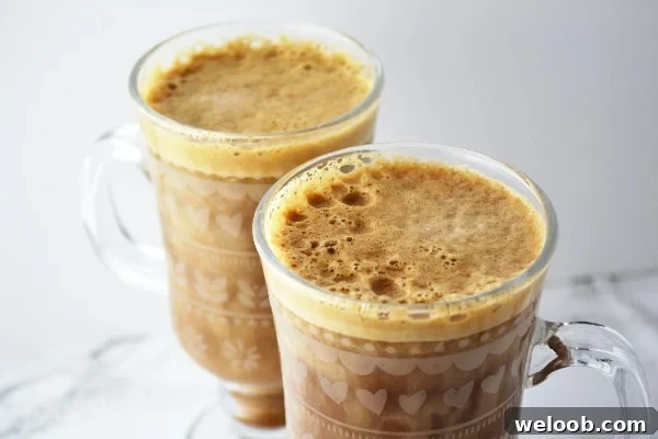 Two glasses of banana milk coffee on a white surface