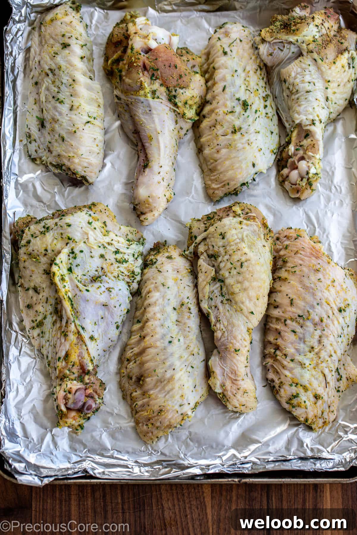 Seasoned turkey wings on a baking sheet.