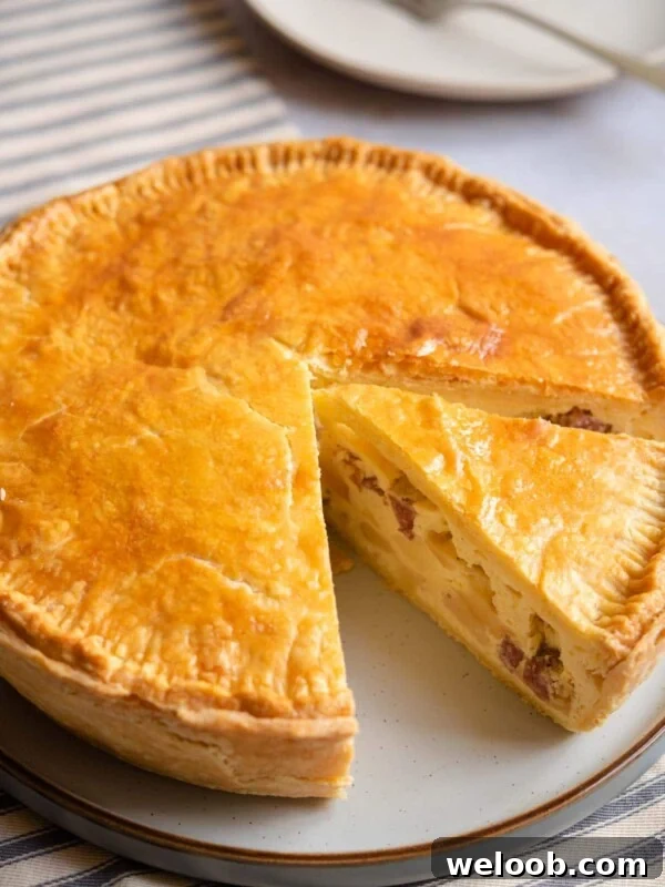 Pizza Rustica on a serving plate with a slice cut