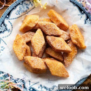 A square image of Crema Fritta (fried custard bites) in a bowl sitting on a wooden surface.