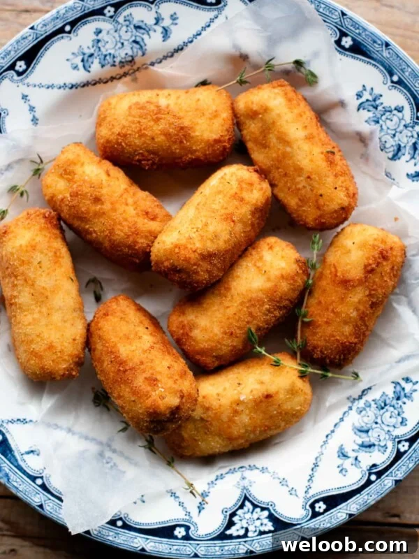 An overhead shot of chicken croquettes in a blue bowl with sprigs of thyme.
