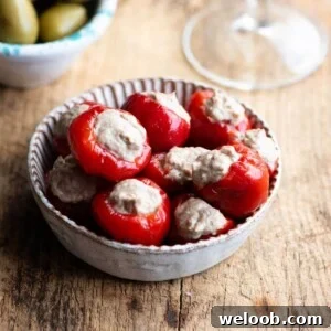 A close up of tuna stuffed cherry peppers in a small dish.