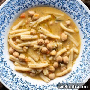 An overhead shot of pasta and chickpeas (pasta e ceci) in a blue bowl.