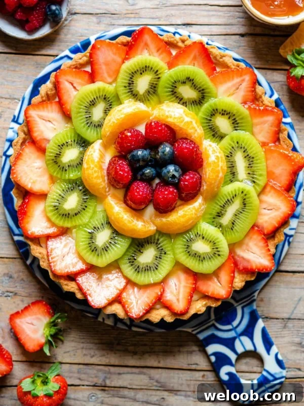 An overhead shot of a fruit tart layered with fresh fruit