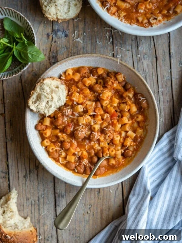 A bowl of pasta fagioli soup with crusty bread