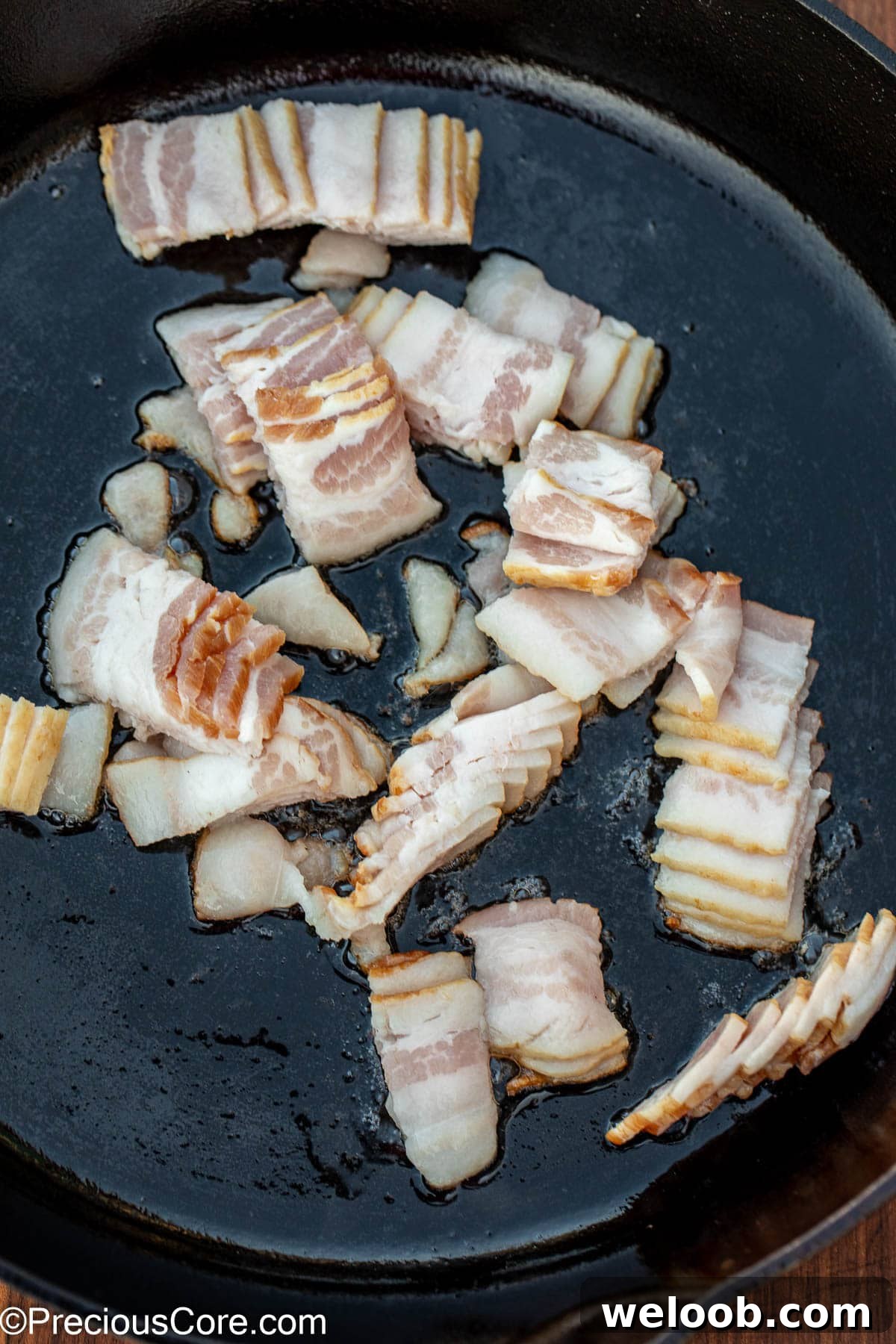 Sliced bacon in a cast iron skillet.