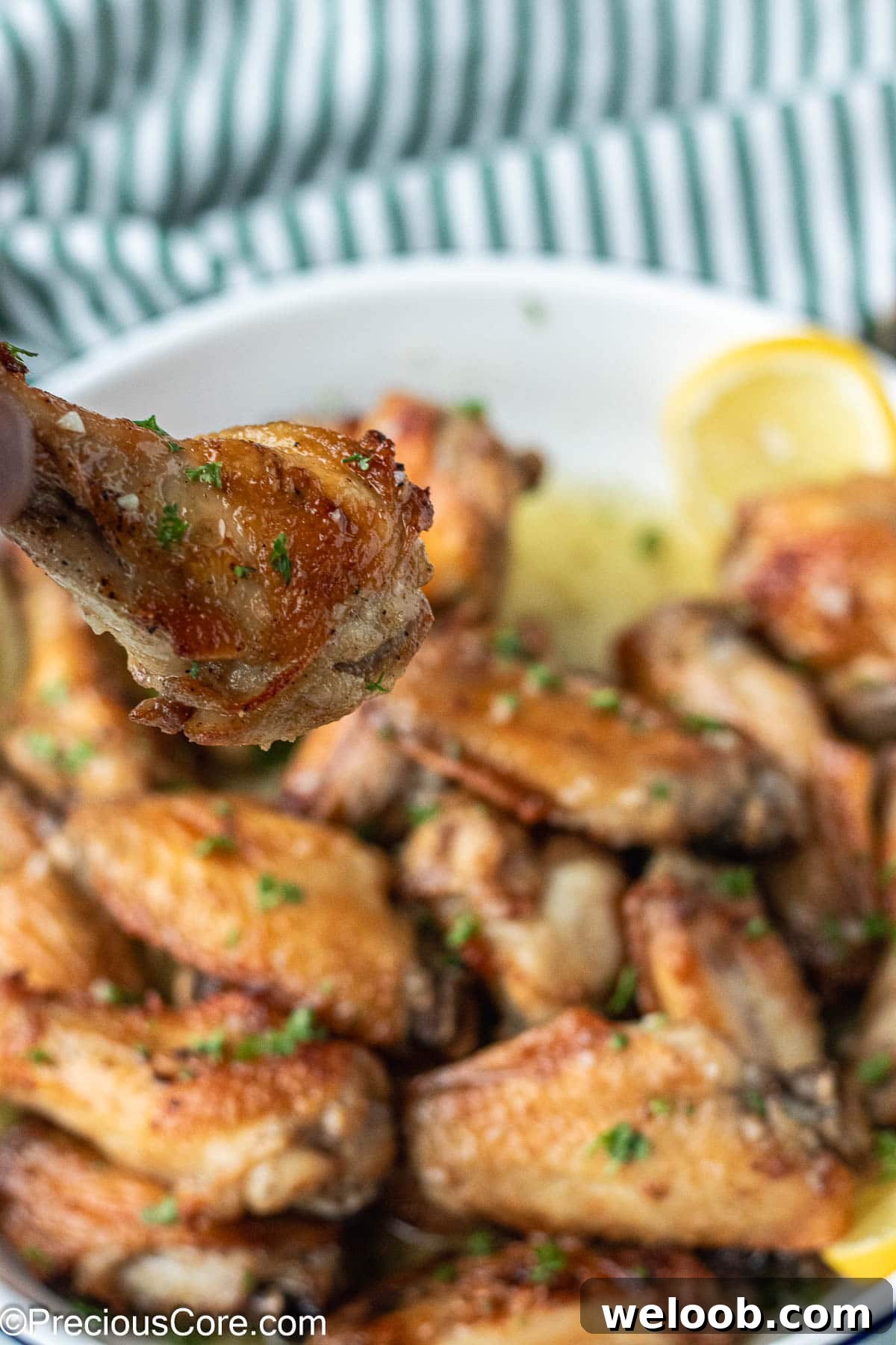 Hand holding a chicken wing.