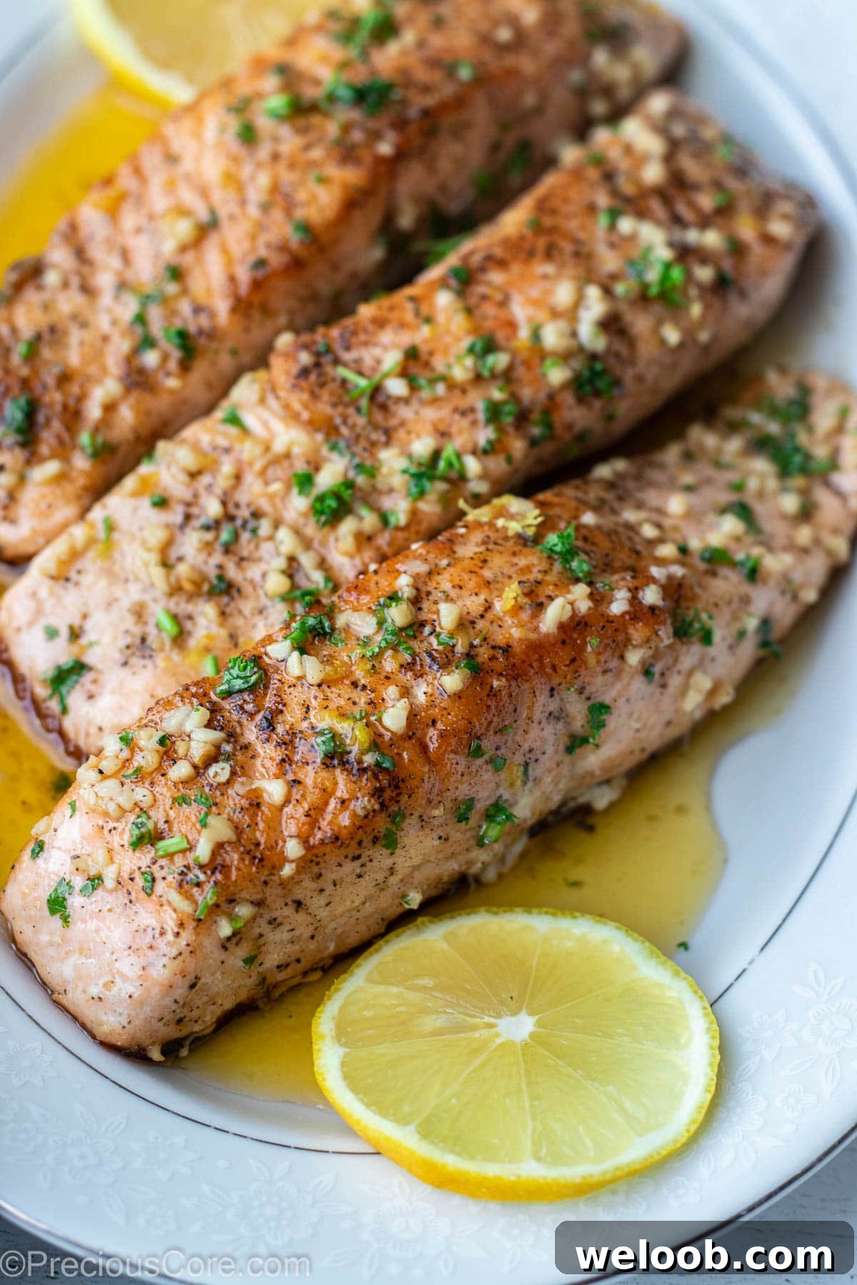 Pan-Seared Lemon Butter Salmon with Garlic and Herbs 10 Cooked salmon fillets on a serving tray over lemon butter sauce.