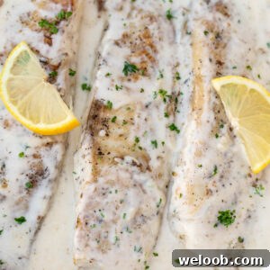 Fish in white sauce with lemon slices.