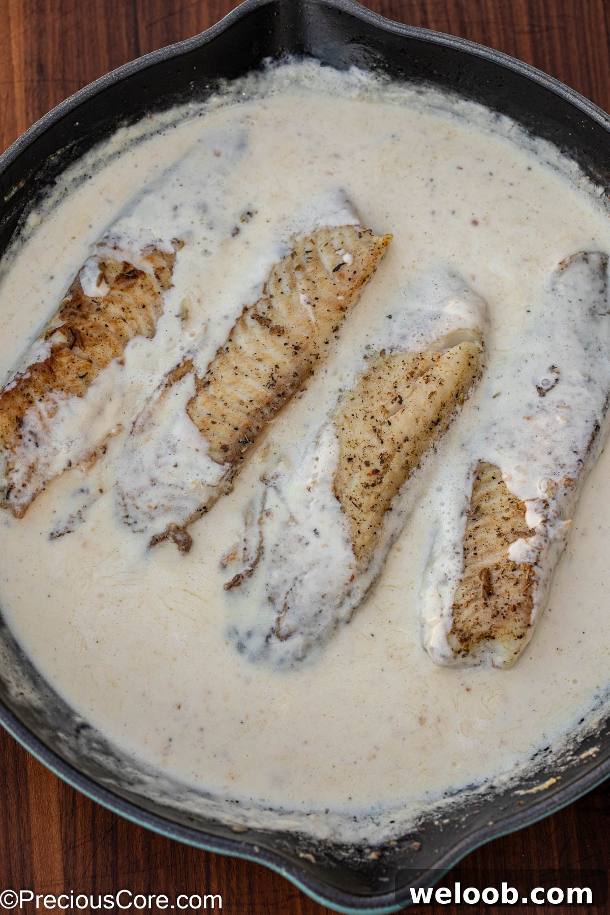 Fish cooking in white sauce.