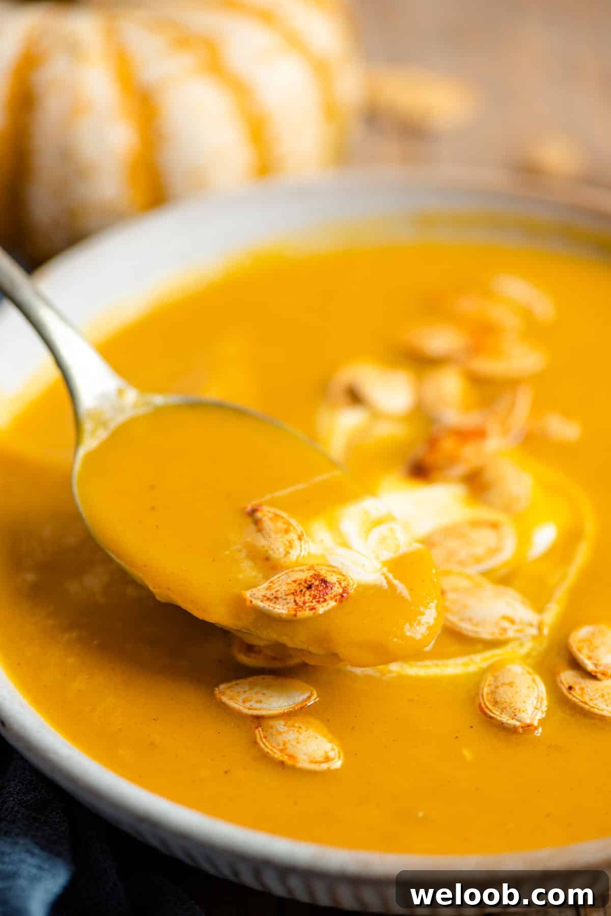 A close up of a spoonful of pumpkin soup
