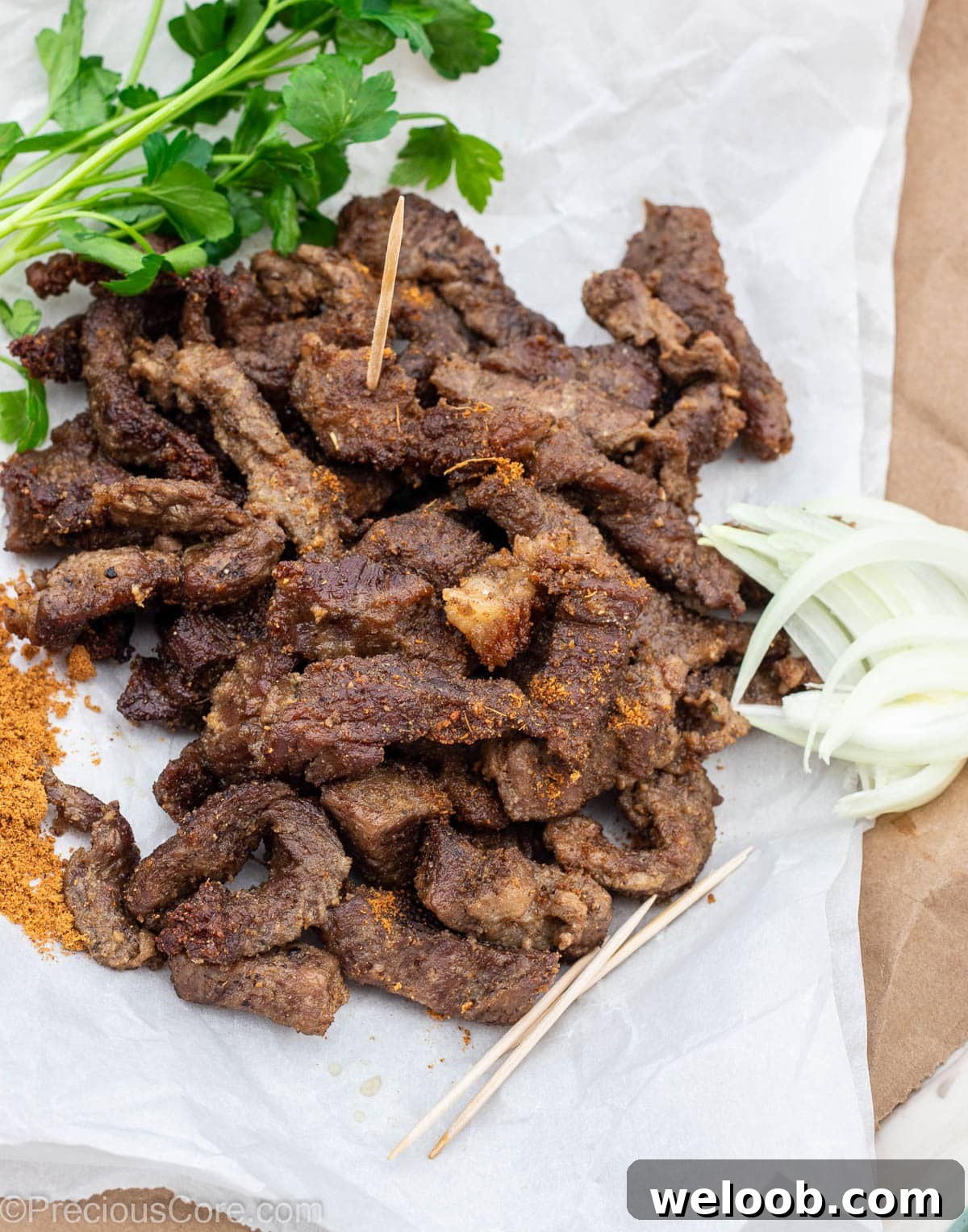Cameroonian grilled meat on parchment paper, served with onions and soya pepper.