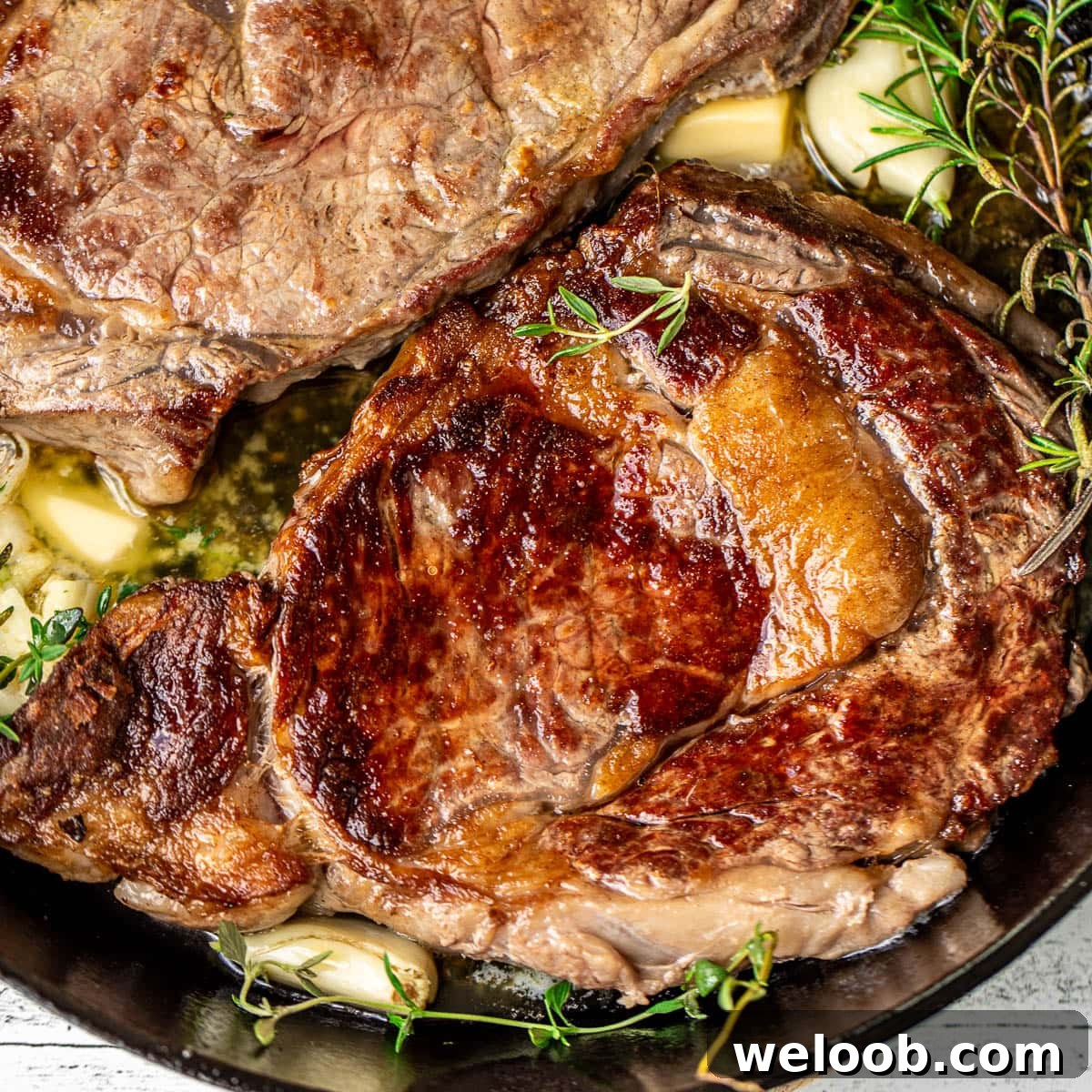 Square image of pan seared ribeye steaks.