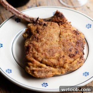 A cropped image of an Italian breaded veal chop on a plate.
